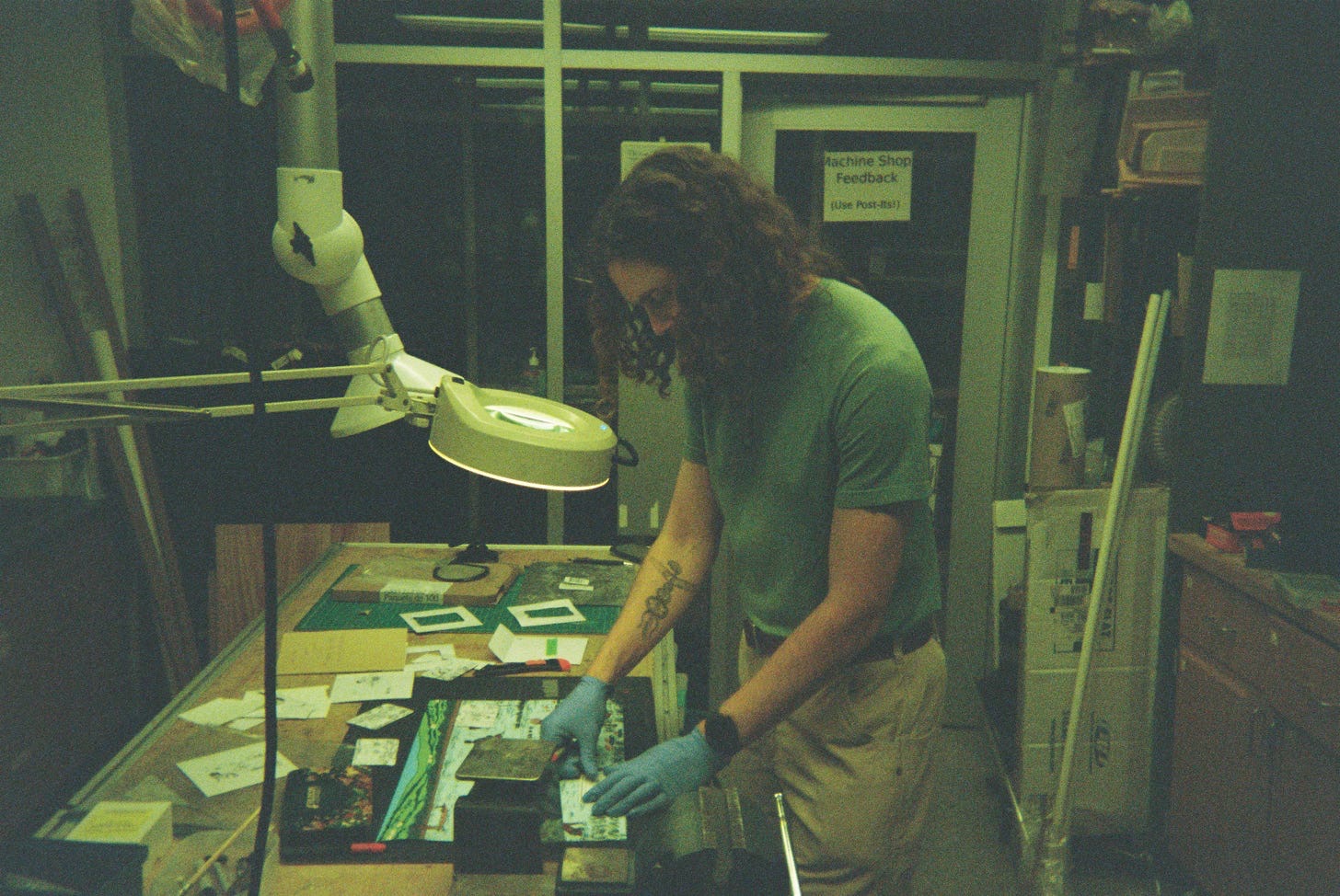 People gathered around a bench examining puzzle pieces and microscopes
